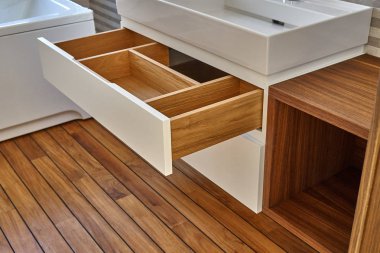 Wall mounted bathroom vanity in luxury bathroom with teak floor. Stylish interior of modern bathroom. Details furniture