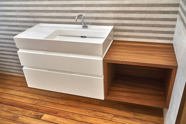 Wall mounted bathroom vanity in luxury bathroom with teak floor. Stylish interior of modern bathroom. Details furniture