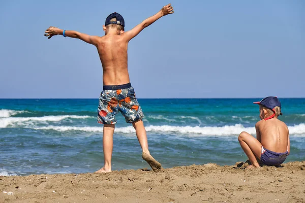 Yaz aylarında kumlu plajda dinlenen oyuncu çocuklar — Stok fotoğraf