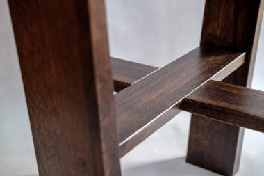 Beyaz arka planda akrilik masa üstü olan ahşap bir sehpa. Yakın plan.