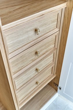 Altın saplı ahşap çekmeceler. Ahşap bir gardırop. Ahşap gardırop, beyaz kapaklı.