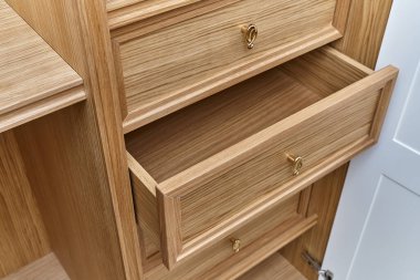 Altın saplı ahşap çekmeceler. Ahşap bir gardırop. Ahşap gardırop, beyaz kapaklı.