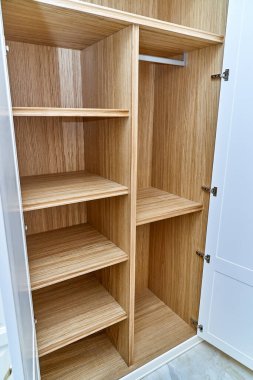 Ahşap çekmeceleri ve rafları olan beyaz bir gardırop açtım. Ahşap bir gardırop. Ahşap gardırop, beyaz kapaklı.