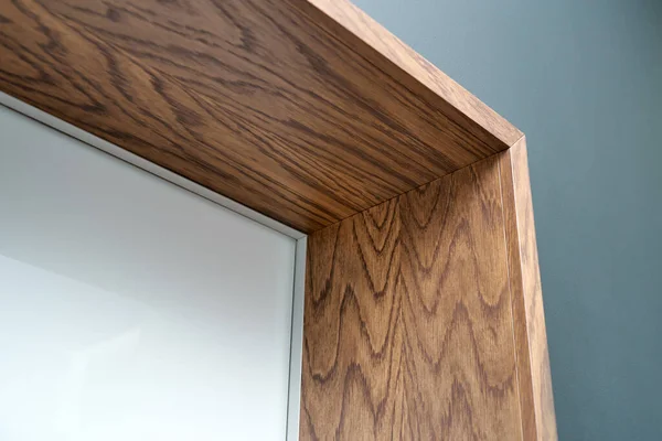 Aluminum frame hidden door with wooden slopes and wooden architraves. Close-up