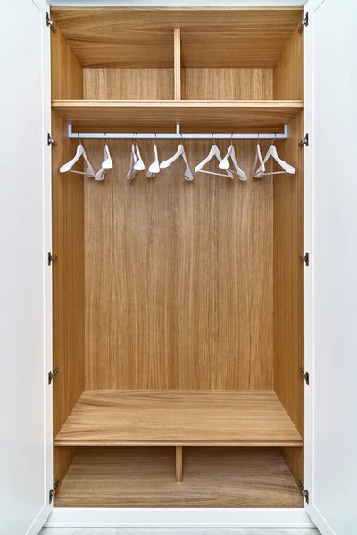 开了的白色衣柜 有木制抽屉和架子 衣柜和白色衣架的木制填充物 带有白色漆制橱柜门的木制衣柜 — 图库照片