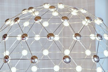 LED lambalı metal çubuklardan yapılmış ağ avizesi. Yakın plan.