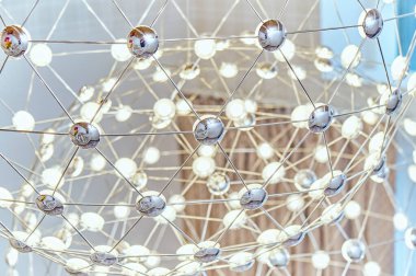 LED lambalı metal çubuklardan yapılmış ağ avizesi. Yakın plan.