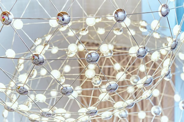 LED lambalı metal çubuklardan yapılmış ağ avizesi. Yakın plan.