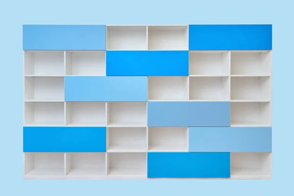 Modern white bookcase with empty shelves and blue doors isolated against blue background