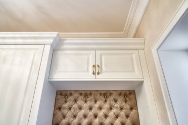 Çağdaş parlak koridorda oturan klasik beyaz gardırop. Klasik mobilyalar. Nakliye eşleşmesi dolabı tezgahı