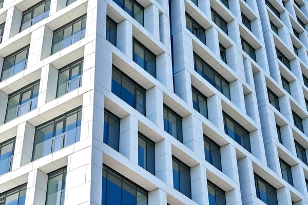 Çağdaş geometrik paneller ve cam pencereler tasarımı ile modern çok katlı binanın alçak açılı köşe manzarası