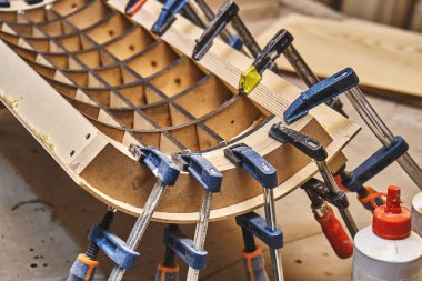 Doğramacılık. Hollywood bükme işlemi yakın plan. Yapıştırma ve klempleme tahta panel bükme. Mobilya imalatı