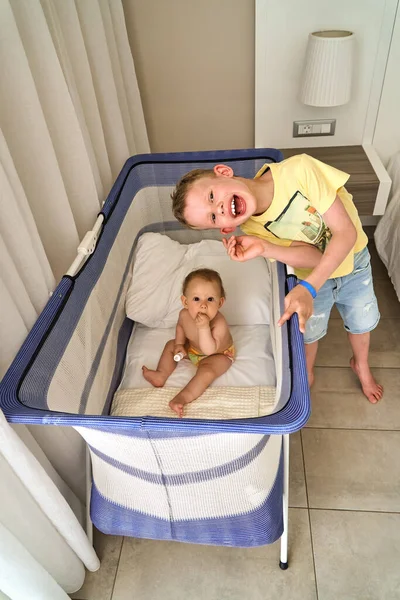 Delighted Barefoot Brother Standing Crib Adorable Baby Looking Camera Cozy — Stock Photo, Image