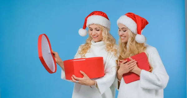 Noel Baba kızları Noel hediyelerine bakar ve sevinirler..