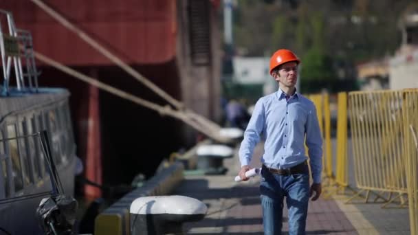 Egy Mérnök Narancssárga Sisakban Rajzzal Kezében Kikötőben — Stock videók