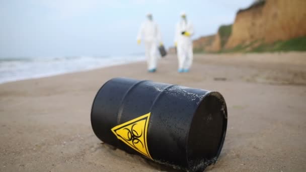 Two Scientists White Protective Suits Approaching Black Barrel Sign Biological — Αρχείο Βίντεο