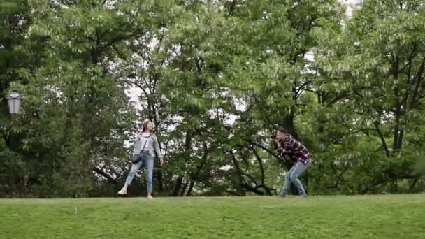 Guy Photographs Girl Motion Background Spring Greenery Beginner Photographer Practices — Stock Video