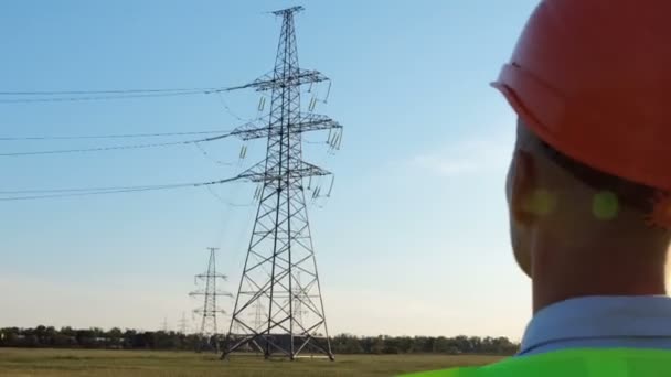 Homme Avec Casque Protection Gilet Signalisation Verte Regarde Ligne Électrique — Video