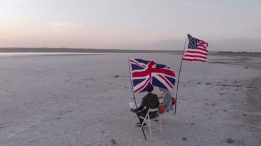 ABD 'li ve İngiliz mühendisler boş bir sitedeki sandalyelerde oturan bir inşaatı tartıştılar.