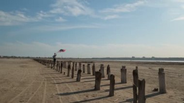 Amerikalı vatansever jiroskoba binip, Amerikan bayrağıyla bayrak direğini sallıyor..