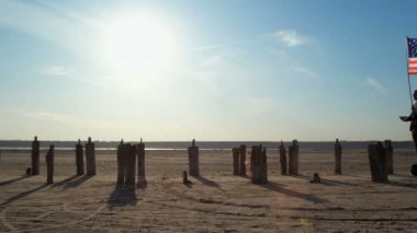 İş kıyafetleri giymiş iki adam, ABD ve İngiltere 'nin bayrağını ellerinde tutan bir jiroskopla birbirlerine yaklaşıyorlar..