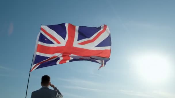 Chlápek Bundě Podívá Dálky Stojí Pod Vlnící Vlajkou Velké Británie — Stock video