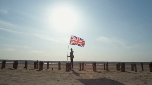 一位英国爱国者手拿着国旗 骑着陀螺仪沿着木杆在蓝天上飞驰 — 图库视频影像