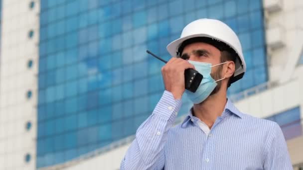 Ingeniero Con Casco Protector Blanco Una Máscara Facial Habla Walkie — Vídeo de stock