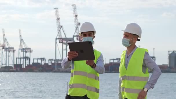 Los Trabajadores Portuarios Trabajan Con Una Tableta Señalan Objeto Frente — Vídeos de Stock