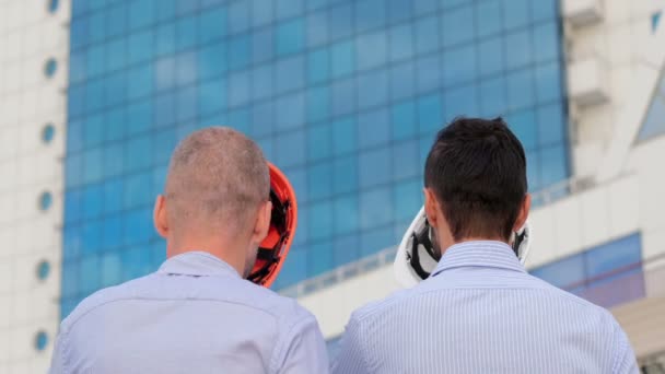 Gli Uomini Indossano Caschi Sicurezza Bianchi Arancioni Sullo Sfondo Edificio — Video Stock
