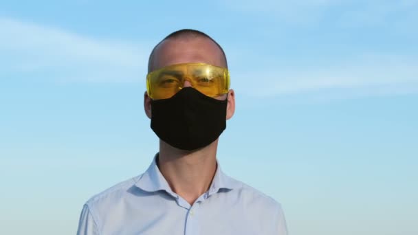 Hombre Con Gafas Amarillas Una Máscara Negra Cara Mira Cámara — Vídeos de Stock