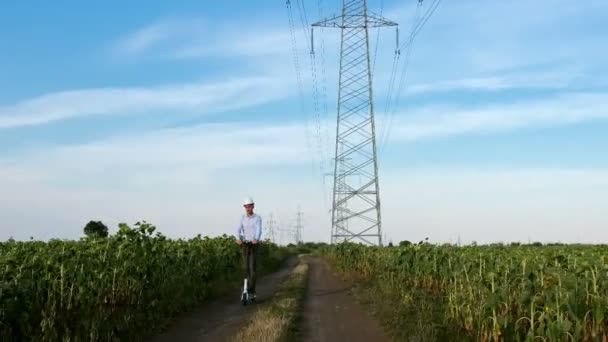 Ingeniero Monta Scooter Eléctrico Carretera Inspeccionando Una Línea Alta Tensión — Vídeo de stock