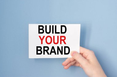 Üzerinde yazı olan el kartı Markanızı oluşturun.