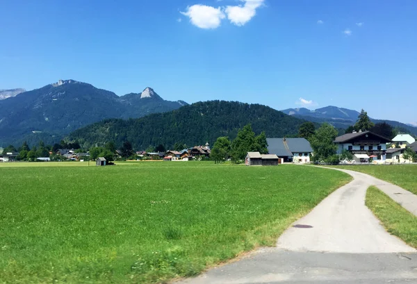 阳光普照的奥地利山上的草地和房屋景观 — 图库照片
