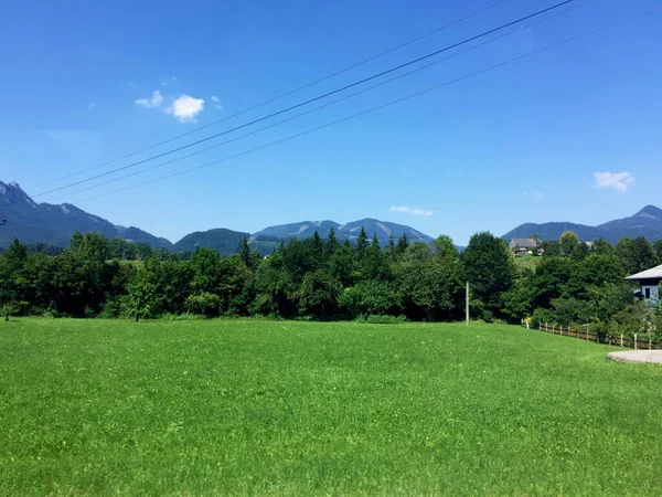 阳光普照的奥地利山上的草地和房屋景观 — 图库照片