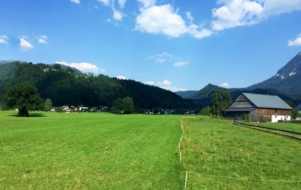 阳光普照的奥地利山上的草地和房屋景观 — 图库照片