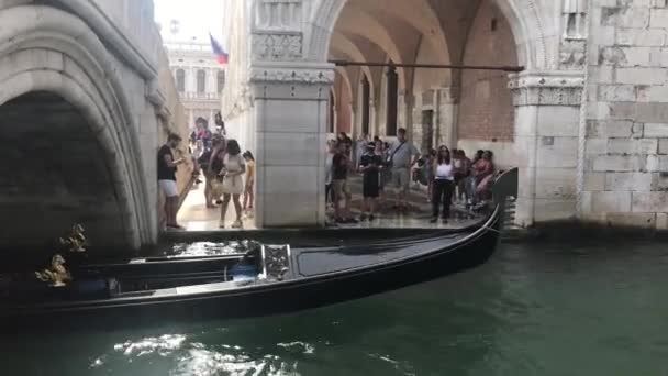 Venise, Italie - 08 / 07 / 2019 : Une gondole sur le Grand Canal, des gondoliers sillonnent leur embarcation dans un étroit canal — Video