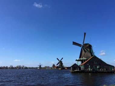 Hollanda 'nın kuzeyinde, Zaanse Schans, Hollanda' da, deniz kıyısında tarihi yel değirmenleri