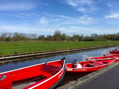 Hollanda 'nın Giethoorn köyünde, Meadow yakınlarındaki nehirde mavi gökyüzüne karşı tekne.