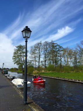 Hollanda 'nın Giethoorn köyünde, Meadow yakınlarındaki nehirde mavi gökyüzüne karşı tekne.