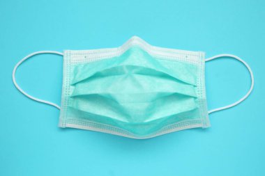 Mavi arka plan korumalı cerrahi yüz maskesi COVID-19 Coronavirus 'a karşı. Sağlık ve Tıp Konsepti