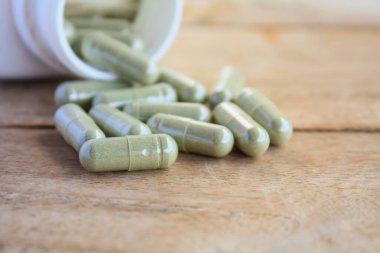 Şişeden dökülen bitkisel kapsüller.