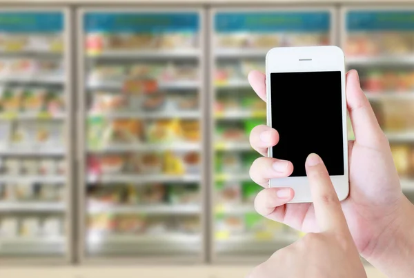 Mão Feminina Segurando Telefone Inteligente Móvel Fundo Borrão Congelador Supermercado — Fotografia de Stock