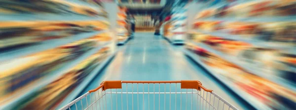 Shopping cart with empty supermarket aisle, motion blur