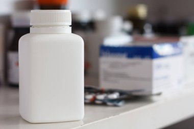 Eczane rafında beyaz ilaç şişesi