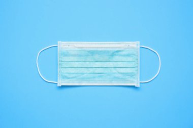 Mavi arka plan korumalı cerrahi yüz maskesi COVID-19 Coronavirus 'a karşı. Sağlık ve Tıp Konsepti