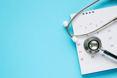 Stetoskop ile takvim sayfası mavi arka plan doktor randevu konsepti