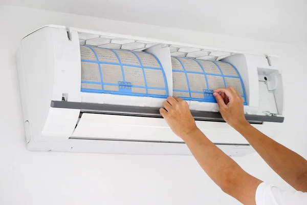 Asian man cleaning air conditioner dirty filter