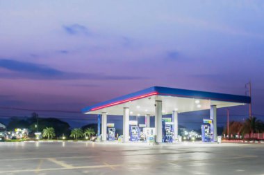 Bulutlu bulanık benzin istasyonu ve gün batımında gökyüzü arka plan için