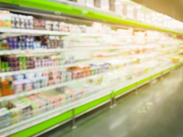 supermarket refrigerator shelves with drinks bottles blurred background